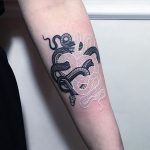 Black and white snake tattoo on the left arm
