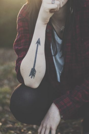 Black arrow tattoo on the right forearm