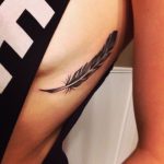 Black feather tattoo on the side