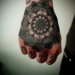 Black mandala tattoo on the hand