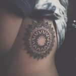 Black mandala tattoo on the ribcage