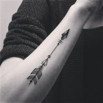 Black minimal arrow tattoo on the forearm