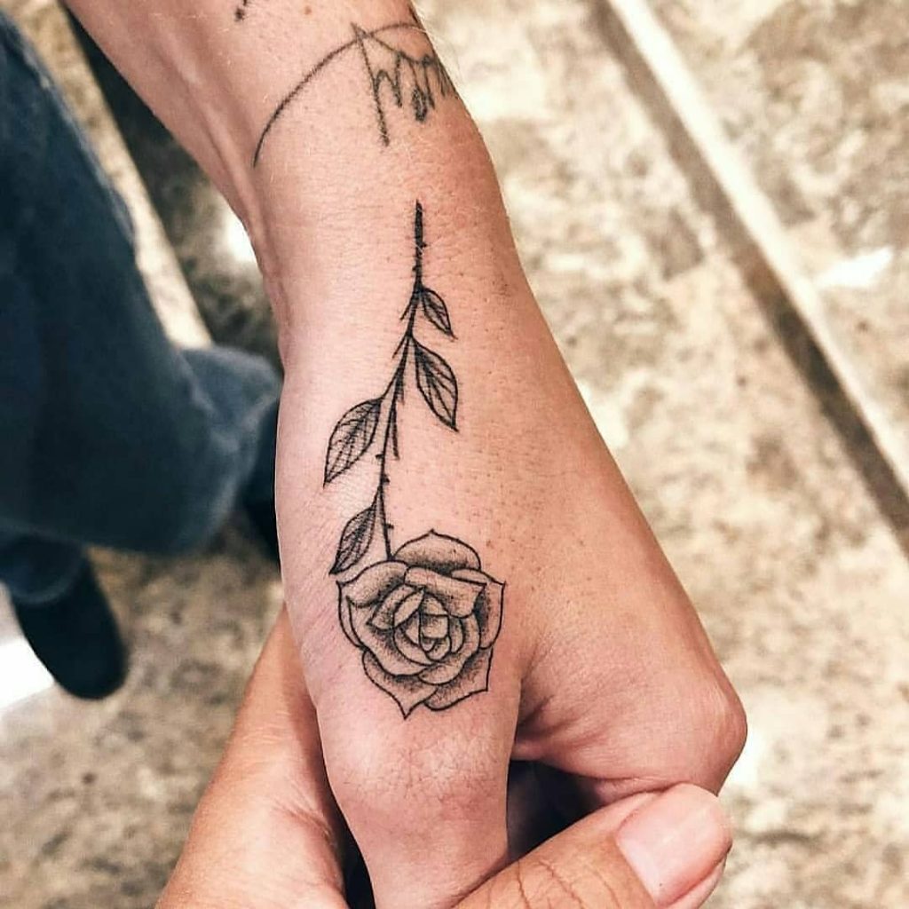 Black rose tattoo on the thumb