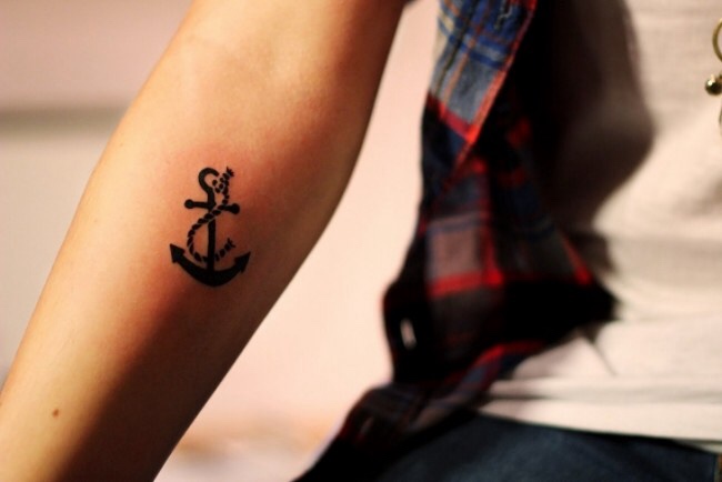 Black small anchor tattoo on the right inner arm