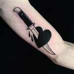 Black stabbed heart tattoo