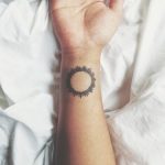 Black sun tattoo on the right wrist
