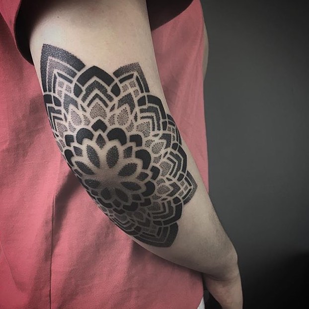Dot-work mandala tattoo on the elbow