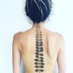 Fern leaf tattoo on the spine