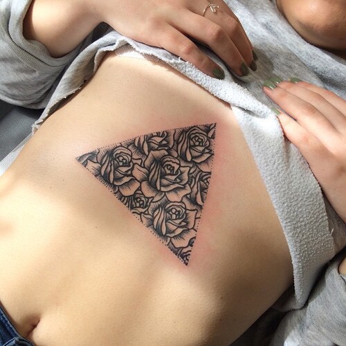 Floral triangle tattoo on the sternum