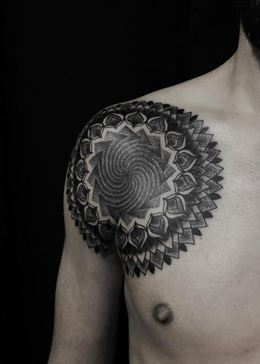 Large black mandala tattoo on the chest and shoulder 