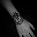 Mandala and bug tattoo on the wrist