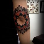 Mandala tattoo around the elbow