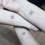 Matching letter M tattoos