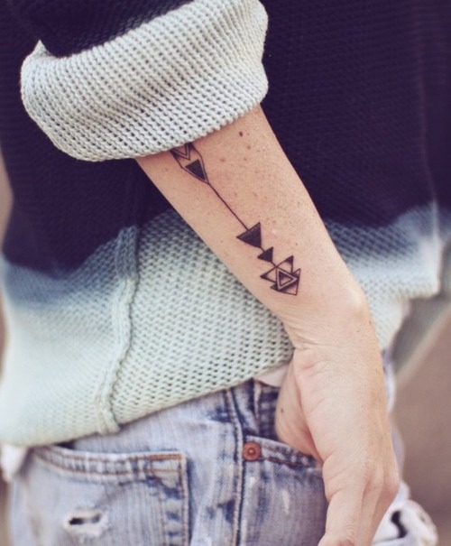Minimal arrow tattoo on the forearm