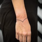 Minimal black line wristband tattoo