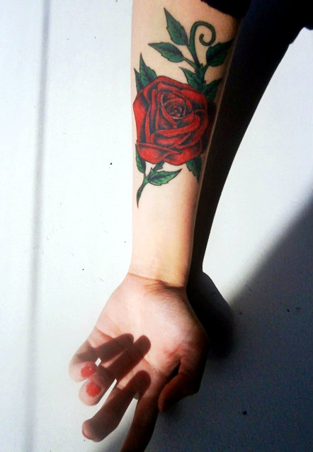 Red rose tattoo with green leaves