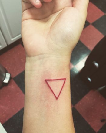 Small red triangle tattoo on the wrist