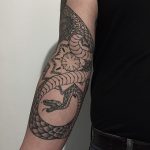 Snake and mandala tattoo on the arm