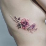 Subtle wildflower tattoo on the rib cage