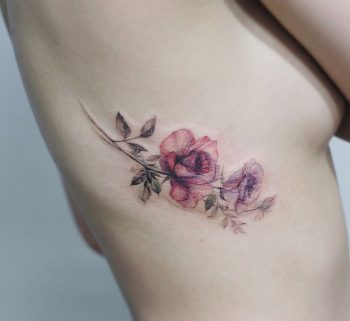 Subtle wildflower tattoo on the rib cage