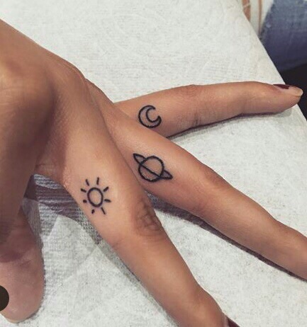 Sun saturn and moon tattoos on the fingers