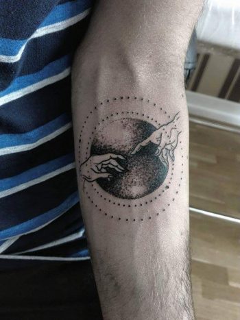 The Creation of Adam by Michelangelo tattoo on the arm