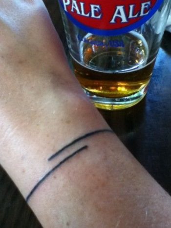 Thin black line tattoo on the wrist