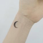 Tiny crescent moon tattoo