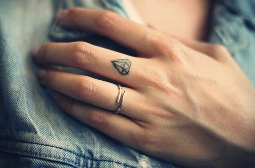 Tiny diamond tattoo on the middle finger