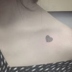 Tiny heart tattoo on the collarbone