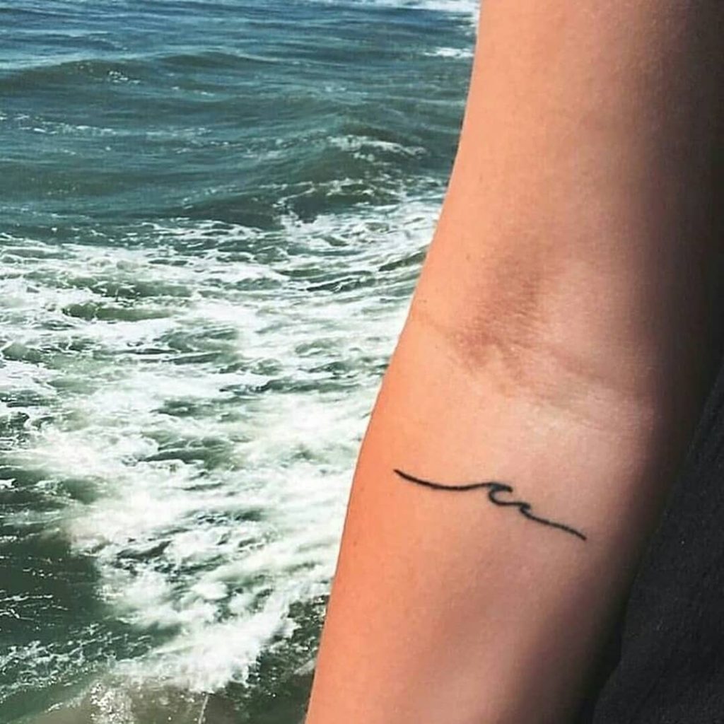 Tiny wave tattoo on the inner arm