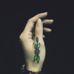 Traditional flower tattoo on a thumb