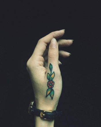Traditional flower tattoo on a thumb