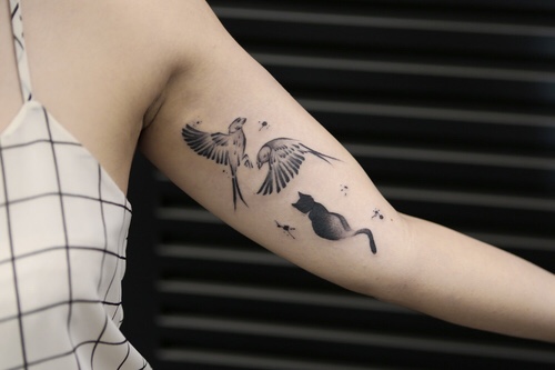 Two birds and a cat tattoo