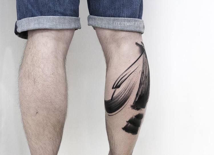 Abstract black paint brush tattoo on the calf