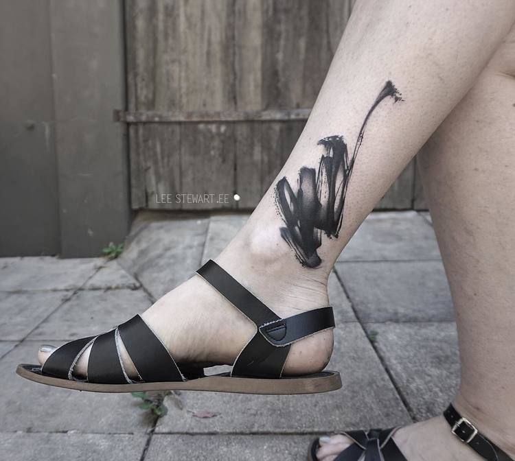 Abstract black paintbrush ankle tattoo