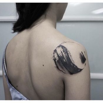 Abstract black tattoo on the right shoulder blade