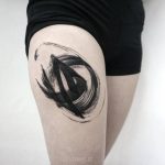 Abstract black tattoo on the thigh