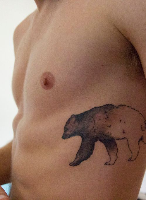 Bear tattoo on the left rib cage