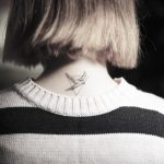 Bird in a triangle neck tattoo