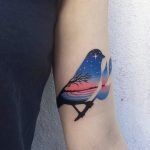 Bird tattoo with an evening landscape