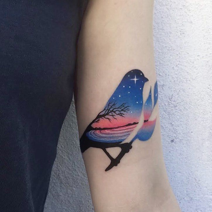 Bird tattoo with an evening landscape