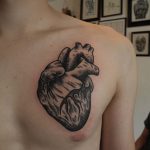 Black anatomical heart tattoo on the chest