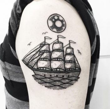Black circular tattoo of a sailing vessel