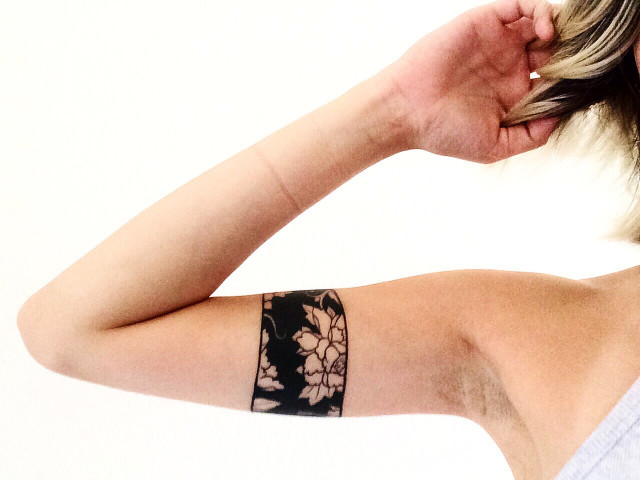 Black floral negative space armband tattoo