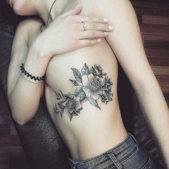Black floral tattoo on the left rib cage