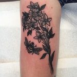 Black flowe and bee tattoo