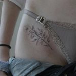 Black flower tattoo on the hip