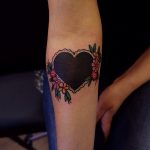 Black heart tattoo with flowers