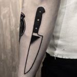 Black knife tattoo on the forearm